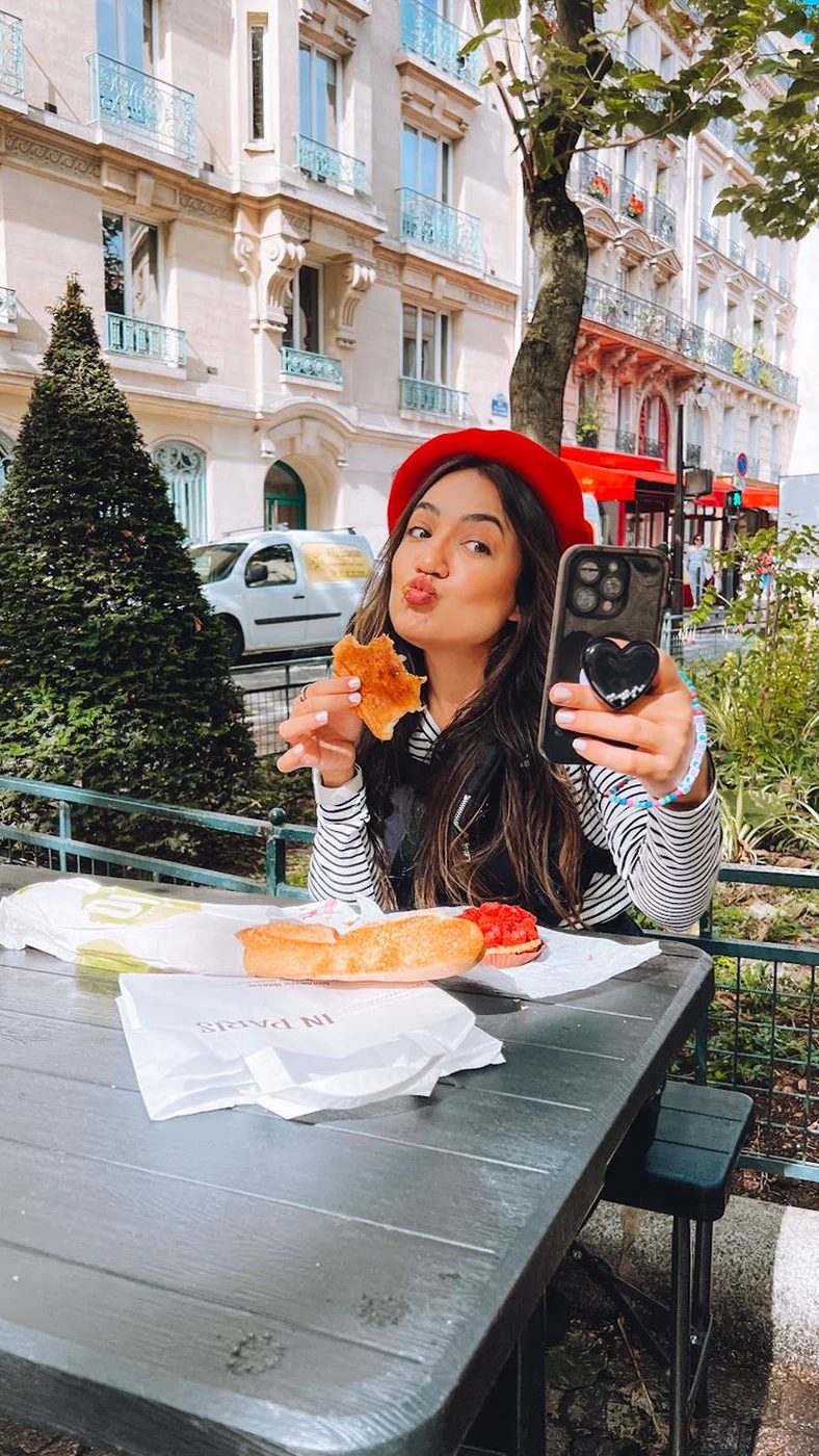 Camila fazendo selfie em um café em Paris